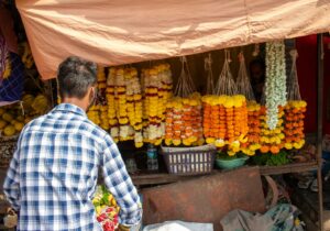 A man standing in front of a fruit stand